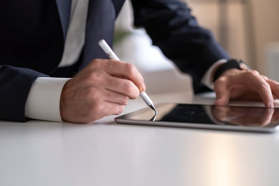 Business Man Using mobile apps on iPad with digital pencil