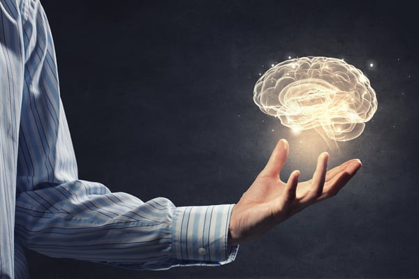 Close up of businessman holding digital image of brain in palm, symbolizing artificial intelligence