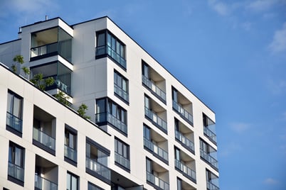 A white apartment building on a sunny blue sky day.